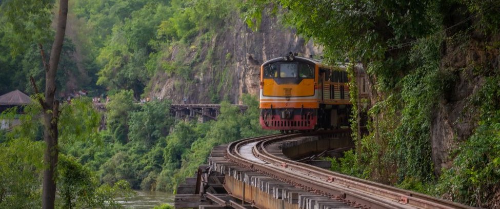Historic train running alongside Panama Canal and jungle scenery
